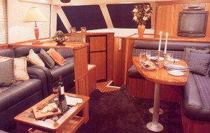The salon of the Riviera 43 includes complete dining and entertaining arrangements, as well as a cabinet-mounted TV/VCR.