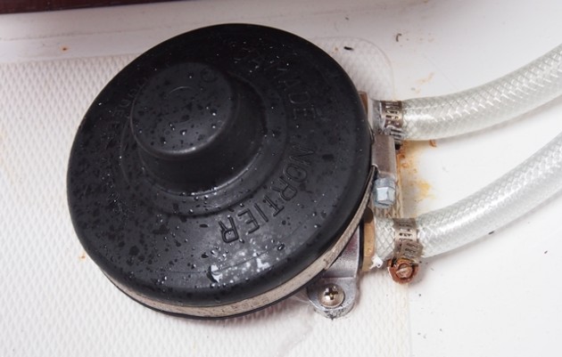 The boatbuilder fitted the hoses to this foot-pump with cheap hose clamps. The bands are stainless steel, but the screws are not.