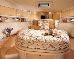 The master stateroom features a queen-size bed and wood cabinetry. 