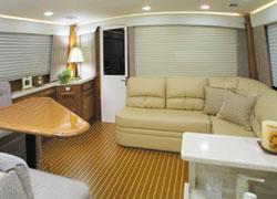 The main saloon can be entered through a single door located starboard of the large aft window, which offers an excellent view aft over the cockpit area.