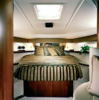 Forward, the boat's master "stateroom" features a roomy pedestal-style double berth with storage below, a hanging locker, two reading lights and a mirrored bulkhead.