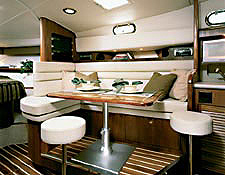 To starboard, forward of the galley, there's an L-shaped convertible dinette, next to a solid teak high-low table inlaid with a brass fish design.
