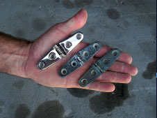 Corroded and discolored strap hinges were replaced with new stainless versions, like the one on the left.
