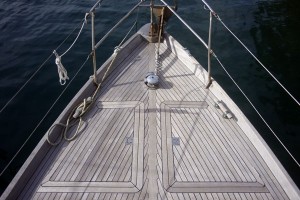 A photo of the teak deck on the foredeck of a sailboat.