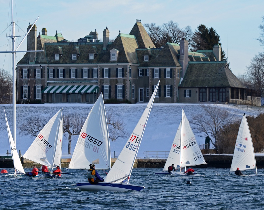 Laser Fleet 413 races on a brisk day with the snowy lawn of the New York Yacht Club as a back drop; the racers launch out of the Sail Newport drysail area, just across the cove. Jeff Stevens photo.