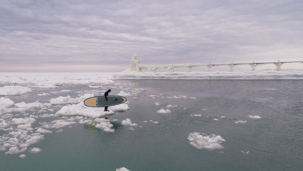 Paddleboarder Karol Garrison contemplates his own private iceberg in the icy world of the lighthouse and breakwater at the western Michigan entrance to the St. Joseph’s River. Photo by Seth Haley/sethhaley.com.